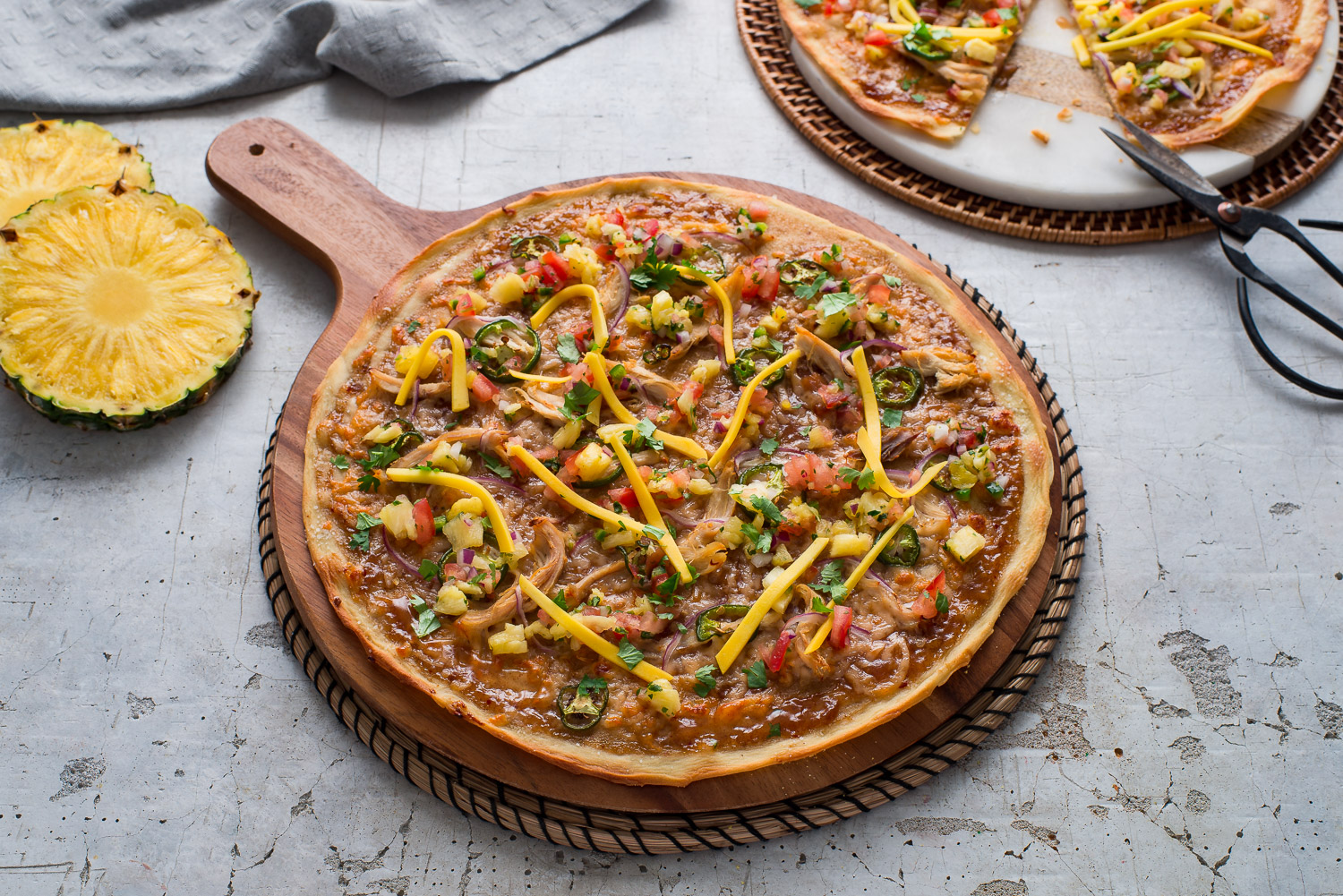 Made with deli roasted chicken, and store-bought pizza dough and pineapple sauce with a kick, this quick and easy pizza is sweet and spicy. 